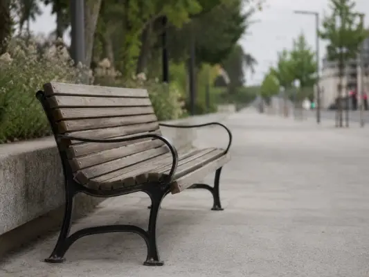 A quiet street with a bench, softly out of focus
